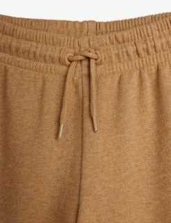 Elasticated waistband and knotted drawstring detail on brown melange sweatpants.