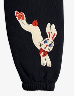 White Rabbit application with a red bow and blue eyes on black sweatpants.