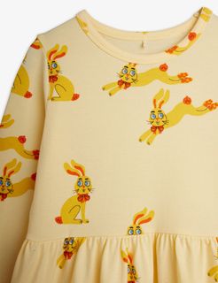 Close-up of a yellow long-sleeved dress featuring a Rabbits print and a gathered waist.