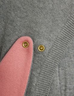 Pink rabbit ear detail and gold snap buttons on the grey melange fine-knit dress.
