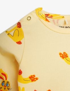 Yellow long-sleeve bodysuit featuring a Rabbits print and metallic snap buttons at the shoulder.