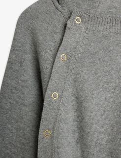Gold-toned snap buttons and ribbed trim on a grey melange fine knit baby jumpsuit.