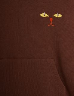 Embroidered cat face and kangaroo pocket detail on a brown sweatdress.