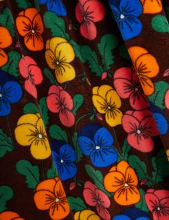 Violas floral print in multiple colors on brown velour fabric with green leaves.