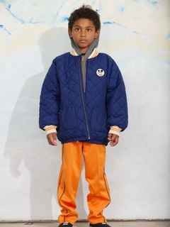 Blue quilted puffer jacket with a Ritzratz patch, zipper closure, and striped ribbed cuffs.