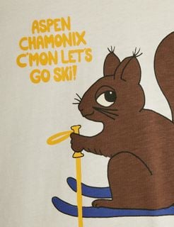 Close-up of a brown Skiing squirrel print on an off-white t-shirt with yellow text reading Aspen Chamonix C'mon let's go ski!