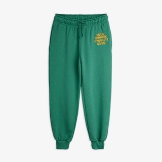 Green organic cotton sweatpants featuring an embroidered Aspen Chamonix text, elastic drawstring waist, and ribbed cuffs.
