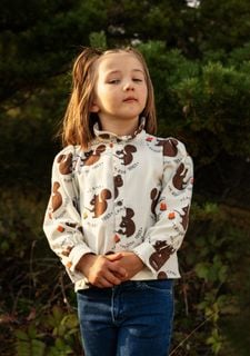 Off-white flannel blouse featuring an all-over brown Squirrel print, high frilled neck, and puffed sleeves.