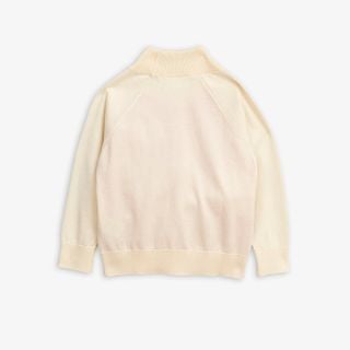 Beige knitted sweater featuring a ribbed high neckline and long sleeves, shown from the back.