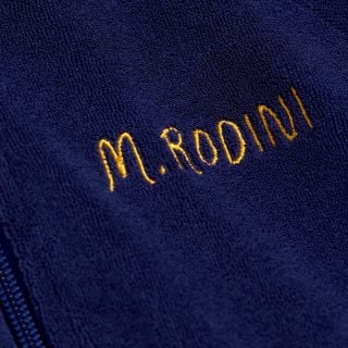 Close-up of navy terry jacket showing yellow M.Rodini embroidery on the chest.
