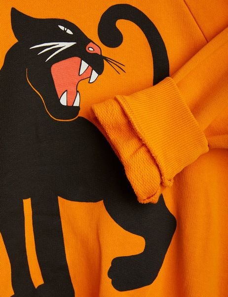 Close-up of the orange sweatshirt showing the black panther print on the front.