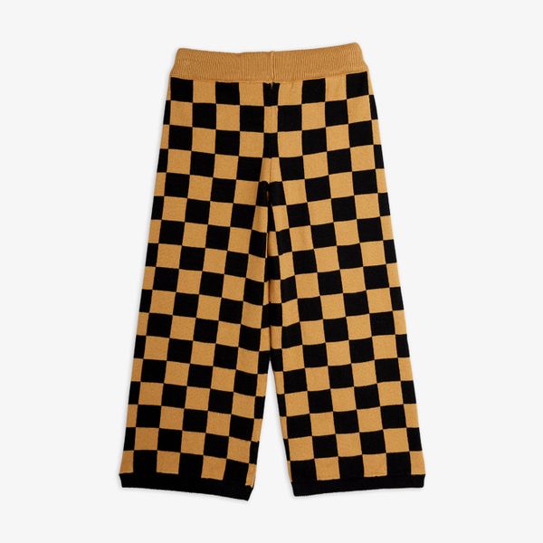 Brown and black chess check knitted trousers featuring a ribbed waistband, shown from the back.