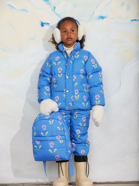Blue puffer jacket and matching trousers featuring a purple Viola print, worn with a matching backpack.