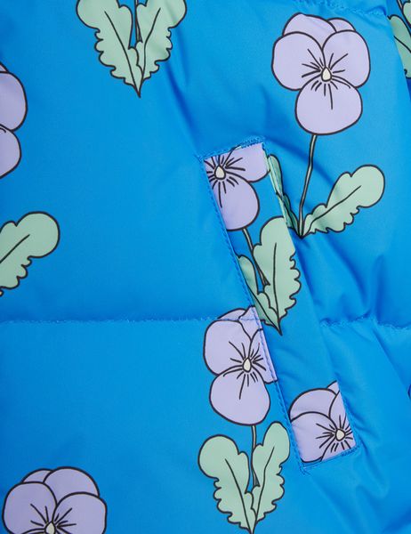 Close-up of a blue padded jacket with a purple Viola flower print and a front pocket detail.