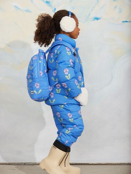 Blue padded citypuffer jacket and matching trousers featuring a purple Viola print, worn with a matching backpack.
