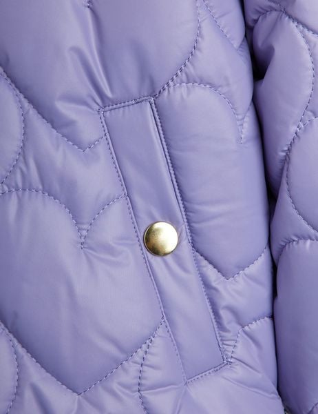 Close-up of a purple heart-quilted puffer jacket featuring a gold snap button and stitching.