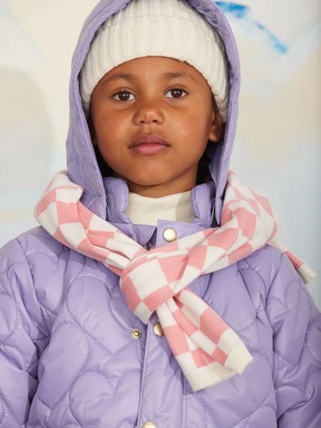 Close-up of a purple heart quilted hooded puffer jacket worn with a pink and white checkered scarf.