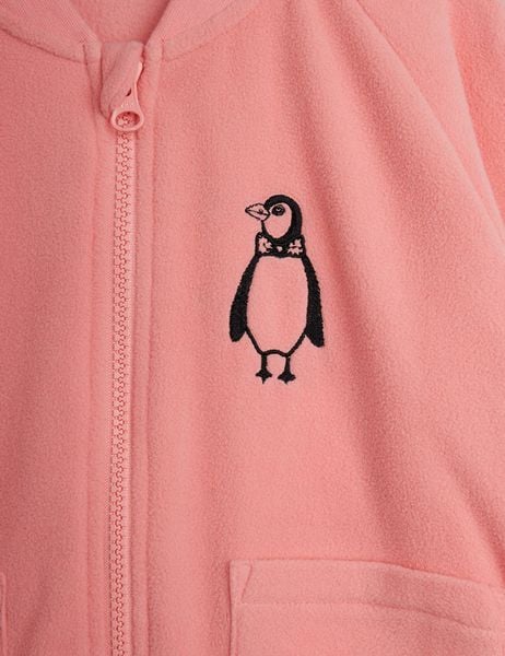 Close-up of a pink microfleece jacket showing a penguin embroidery and a zipper on the chest.