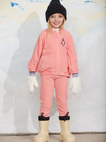 Pink zip-up microfleece jacket with a penguin embroidery, worn with matching pants and white mittens.