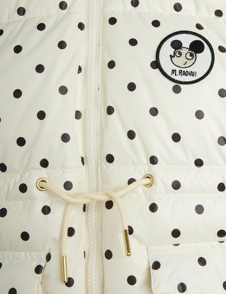 Close-up of an off-white heavy puffer jacket with black polka dots and a Ritzratz patch.