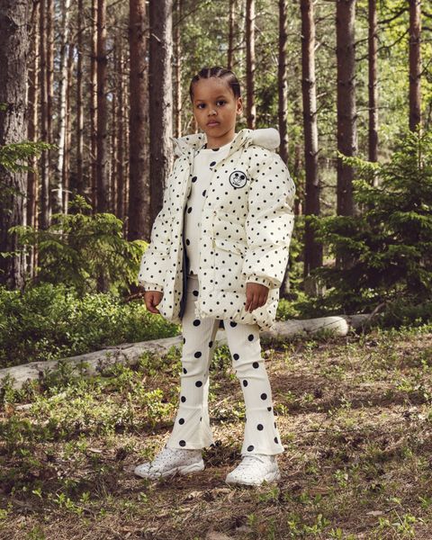 Off-white heavy puffer jacket featuring polka dots and a Ritzratz patch, worn outdoors.