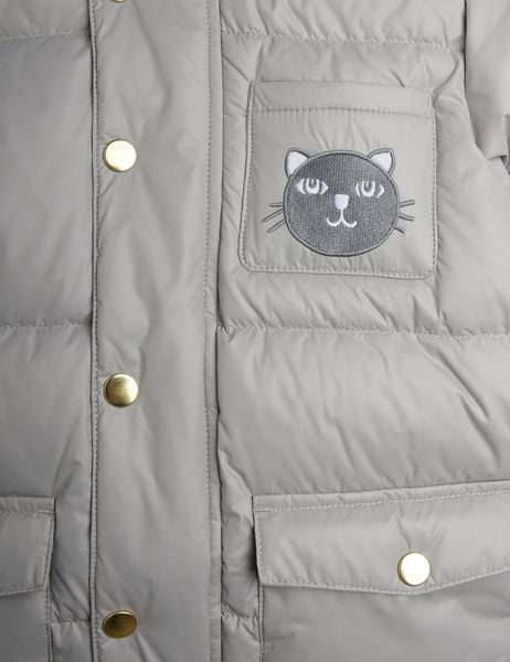 Close-up of a grey puffer jacket featuring gold-toned snap buttons and a cat face patch on the chest pocket.