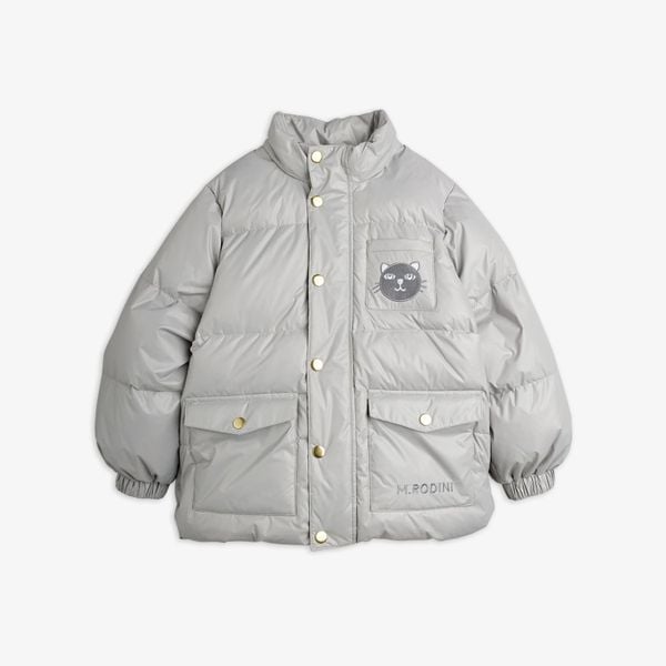 Grey heavy puffer jacket featuring gold-toned snap buttons, front flap pockets, and a cat face patch on the chest.