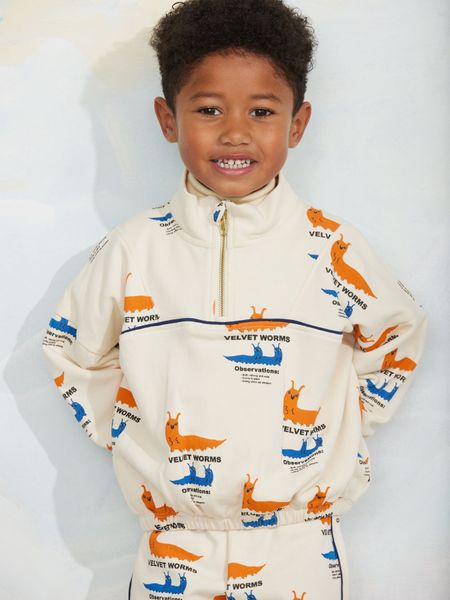 Off-white half-zip sweatshirt featuring an orange and blue Velvet worms print and a stand collar.