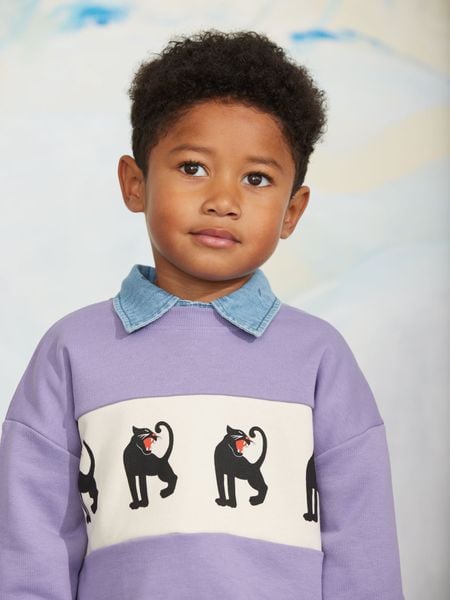 Purple sweatshirt featuring a cream panther print chest panel and a blue collar, worn by a child.