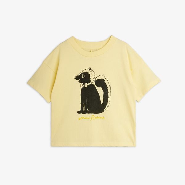 Yellow short-sleeved top featuring a Skunk print with a bow tie and script logo.