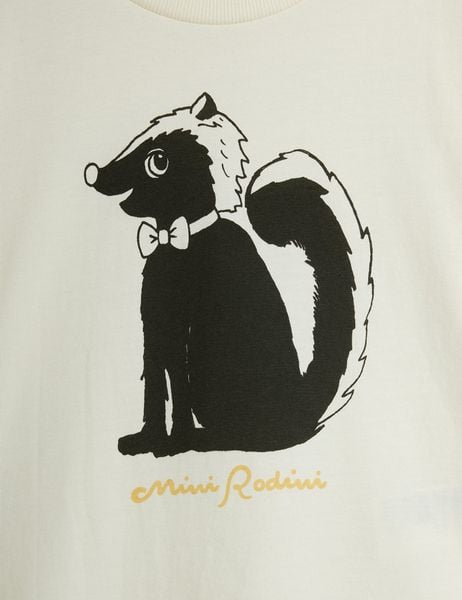 Close-up of a black and white Skunk print wearing a bow tie on an off-white background with a yellow brand logo.