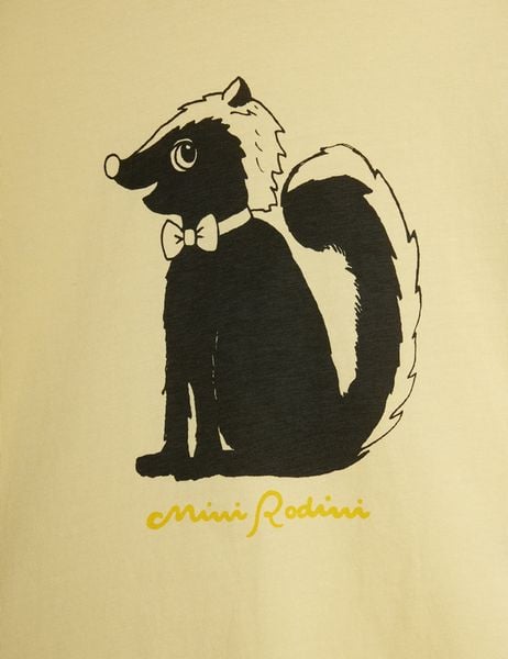 Close-up of a black and white skunk print wearing a bow tie on a yellow background with yellow Mini Rodini script.