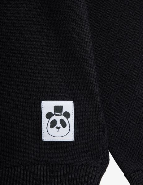 Black fine knit jumper detail featuring a white label with a panda wearing a top hat.
