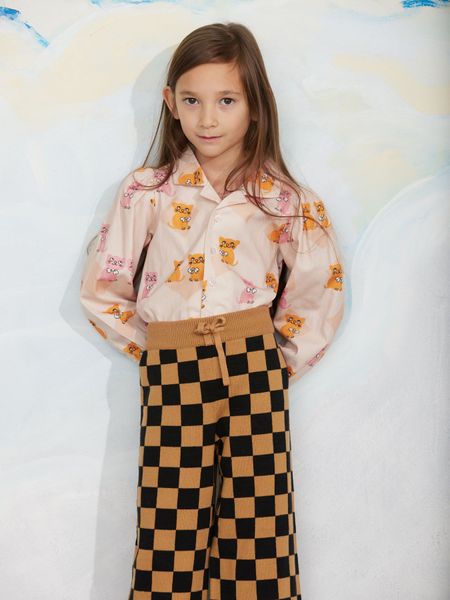 Beige woven blouse featuring a Kittens print, camp collar, and puff sleeves, paired with checkered trousers.