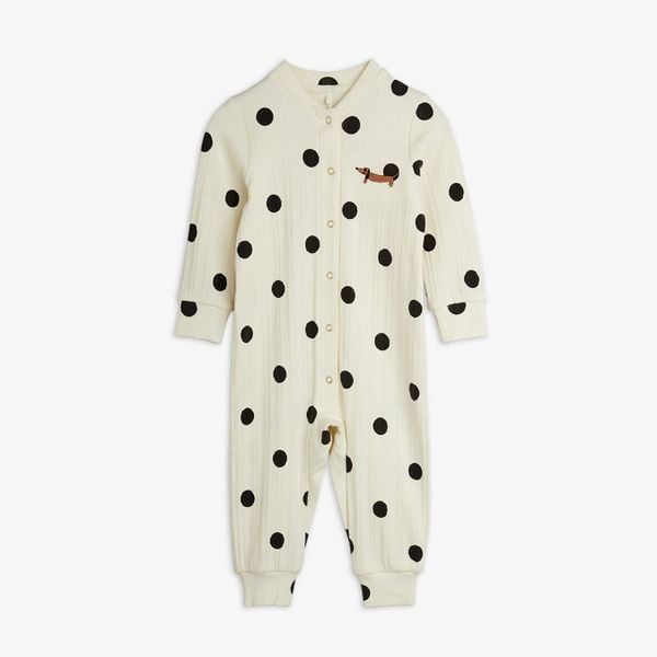 Off-white jumpsuit featuring a black dots print, snap buttons down the front, and a dachshund dog patch on the chest.