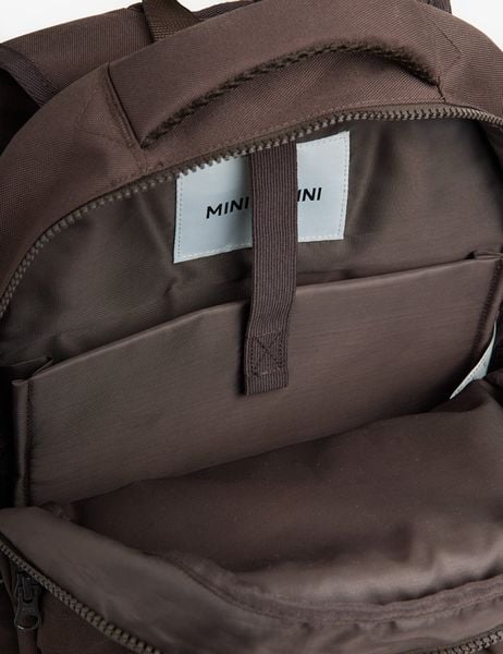 Brown school backpack interior showing lining, inner pocket, zipper, and brand label.