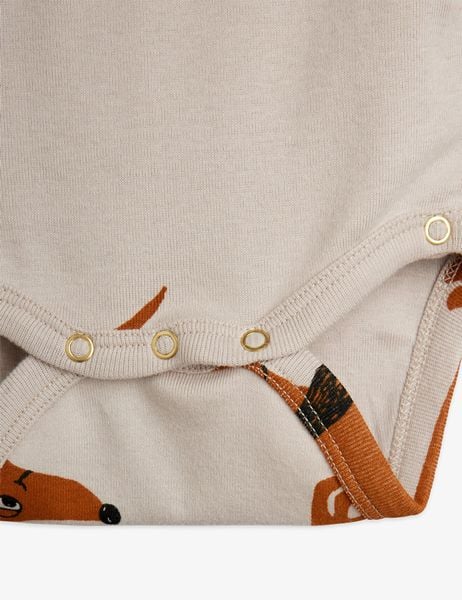 Gold-tone snap buttons at the crotch of a grey bodysuit with a brown dog print.