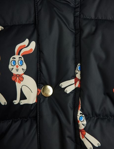 Close-up of a black puffer jacket featuring a Rabbits print and a gold snap button.