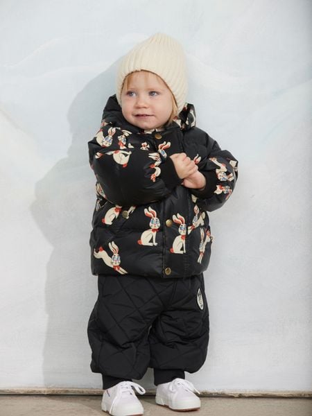 Black hooded puffer jacket featuring a rabbit print and ribbed cuffs, worn by a child in a beanie.