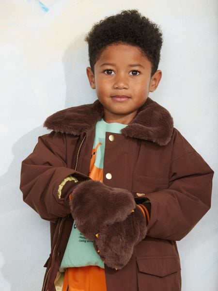 Brown padded nylon parka with a soft faux fur collar, worn by a child.
