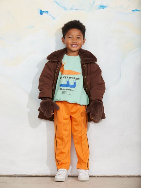 Brown padded parka with faux fur collar and matching mittens, worn by a child.