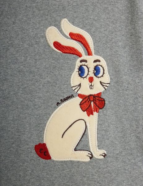 Cream rabbit application with a red bow and blue eyes on grey melange ribbed fabric.
