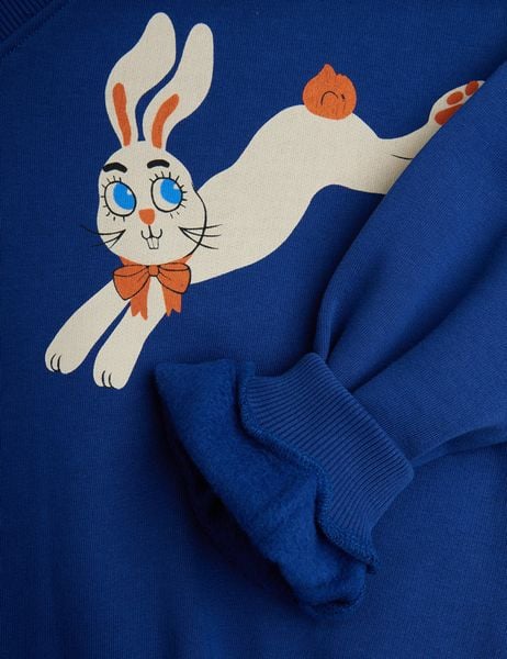 Close-up of a blue sweatshirt featuring the Rabbits print and a ribbed sleeve cuff.