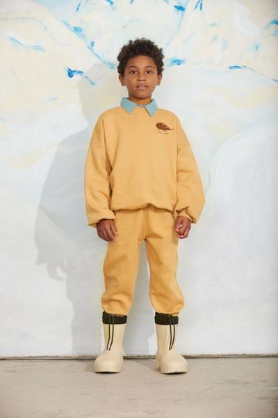 Beige sweatshirt featuring an embroidered elephant shrew and matching trousers on a child model.