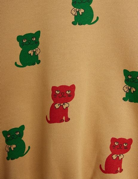 Close-up of beige sweatshirt featuring a Kittens print with red and green cats.