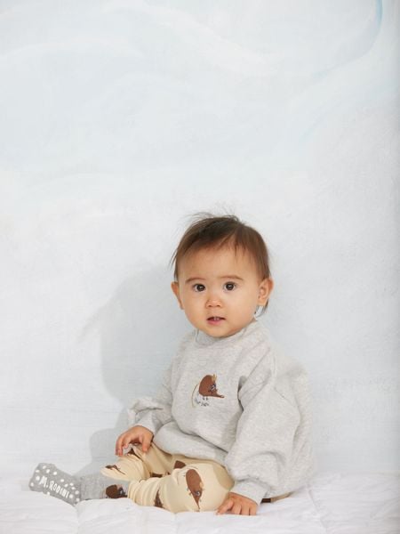 Beige leggings with an elephant shrew print, worn by a child sitting.