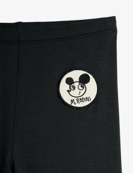 Black leggings close-up featuring a round white Ritzratz patch and an elastic waistband.