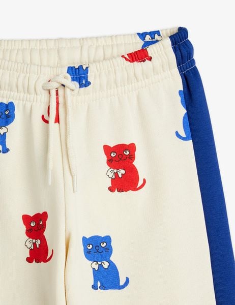 Off-white sweatpants with red and blue Kittens print, elastic drawstring waist and blue side panels.