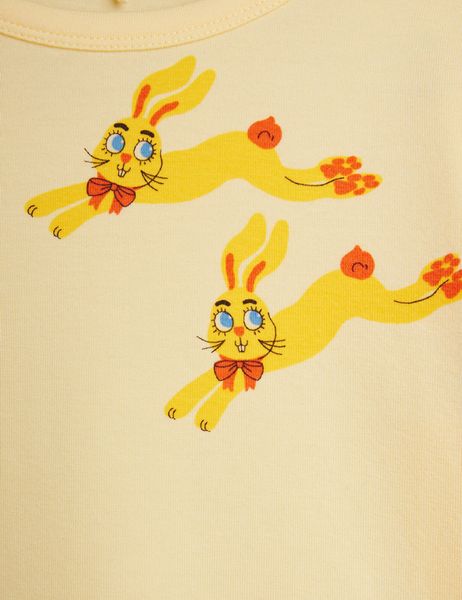 Close-up of yellow long-sleeved top featuring a Rabbits print with leaping yellow rabbits wearing red bows.