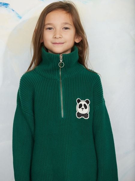 Green chunky knit half-zip sweater featuring a panda patch on the chest, worn by a child.